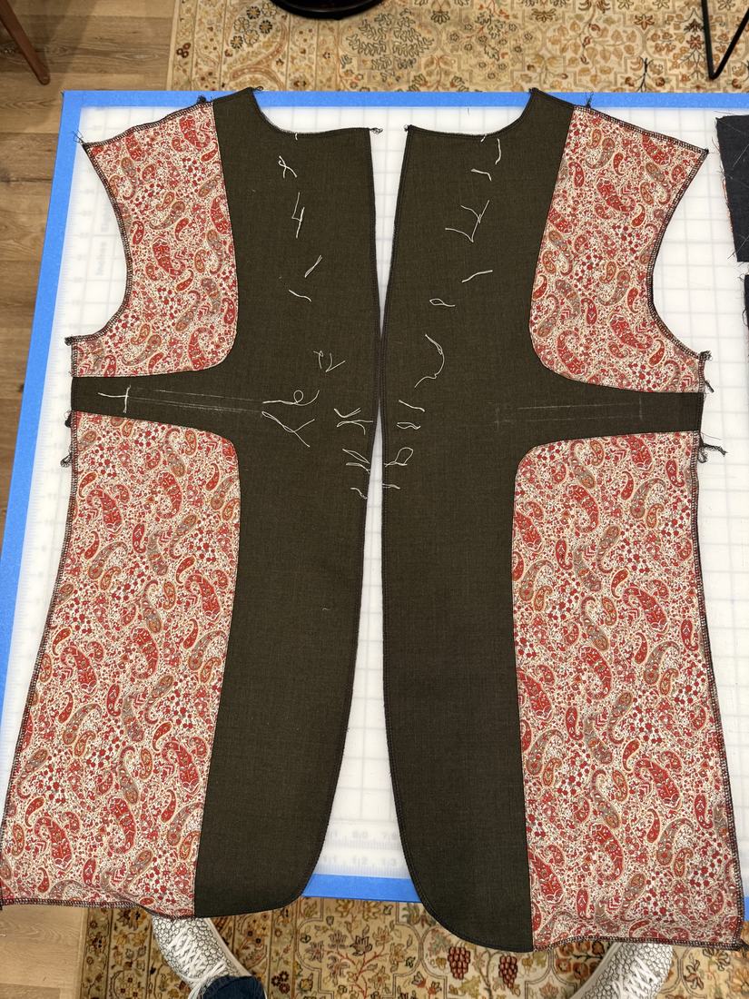 The lining unit laid flat: olive facings joined to paisley side panels.